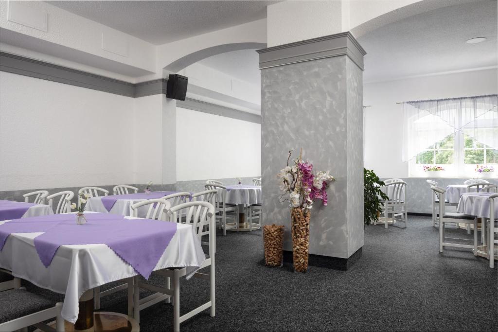 sala bankietowa z purpurowymi stołami i białymi krzesłami w obiekcie Hotel Ferdinand w Mariańskich Łaźniach