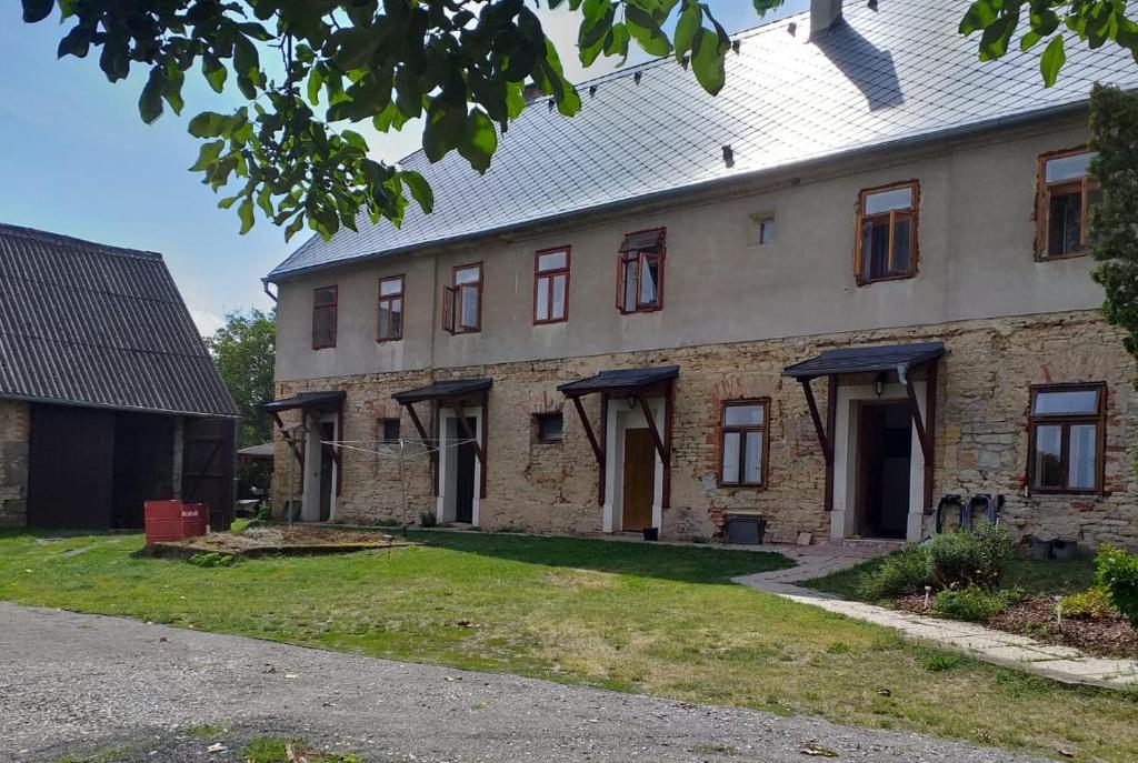 un vieux bâtiment en briques avec des fenêtres et une cour dans l'établissement Apartmán Chrpa, 