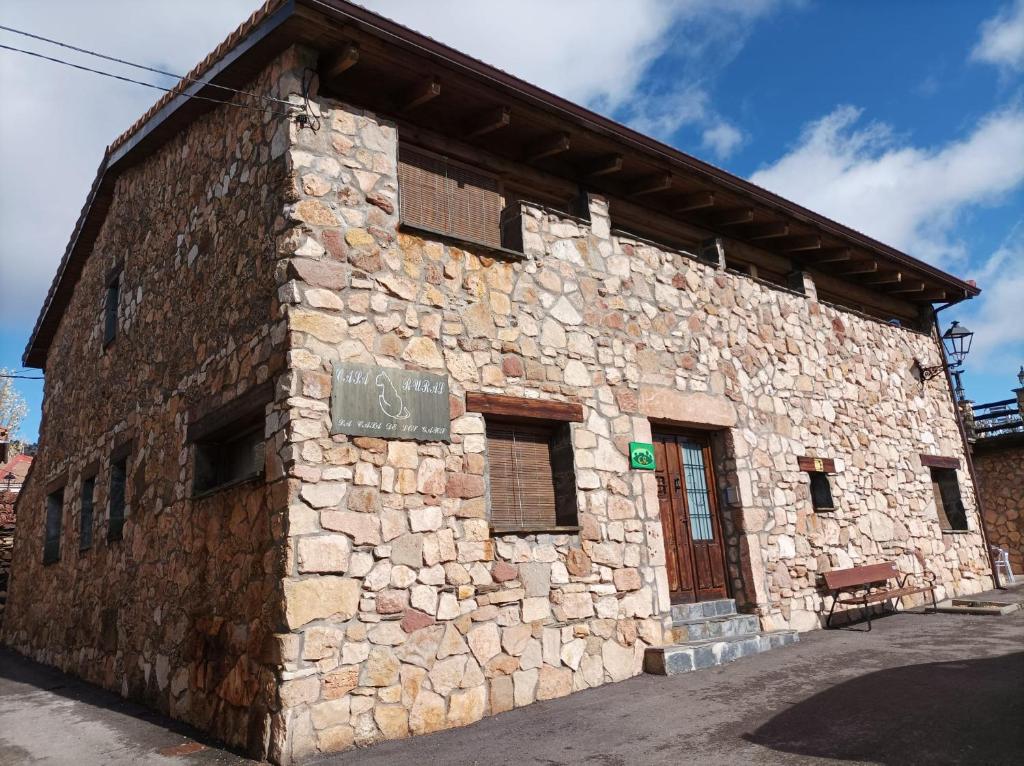 a stone building with a sign on the side of it at La Casa de los Gatos in Condemios de Abajo