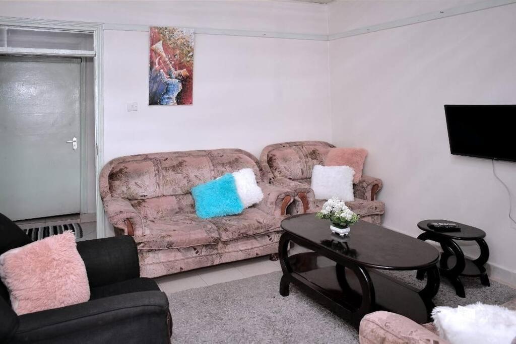ein Wohnzimmer mit einem Sofa und einem Tisch in der Unterkunft Golden One-bedroom serviced apartment with free WiFi in Kisii