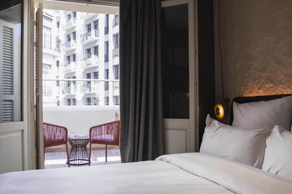 Habitación de hotel con cama y balcón en Letoh Letoh Gran Vía en Madrid