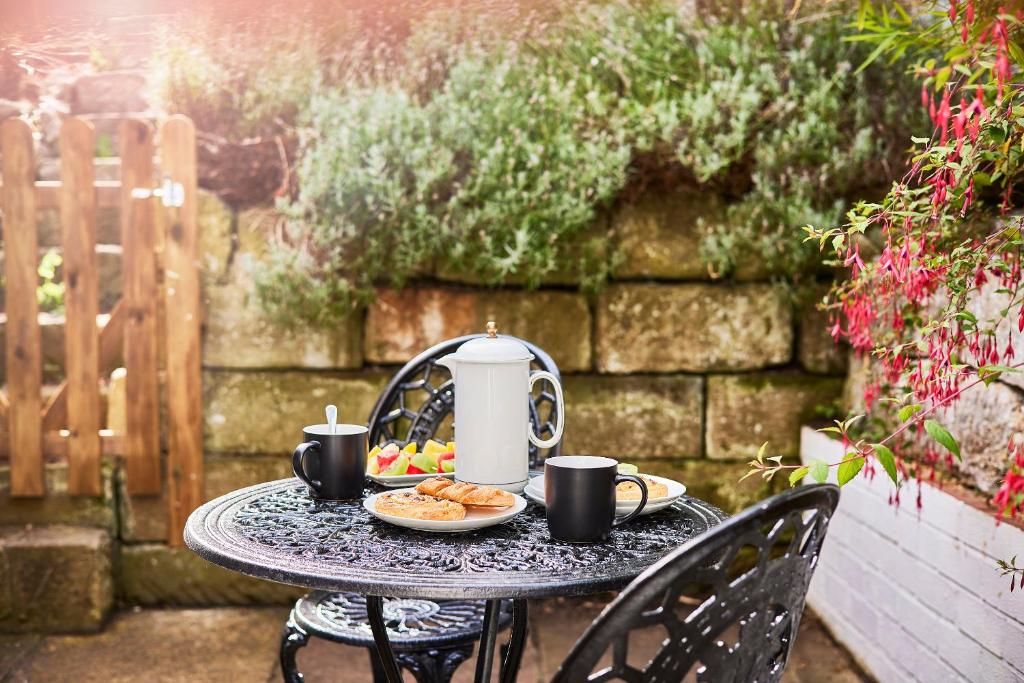 a table with a tea kettle and a plate of food at Lux Central Whitby Near Pannett Park/Cinder Trail in Whitby