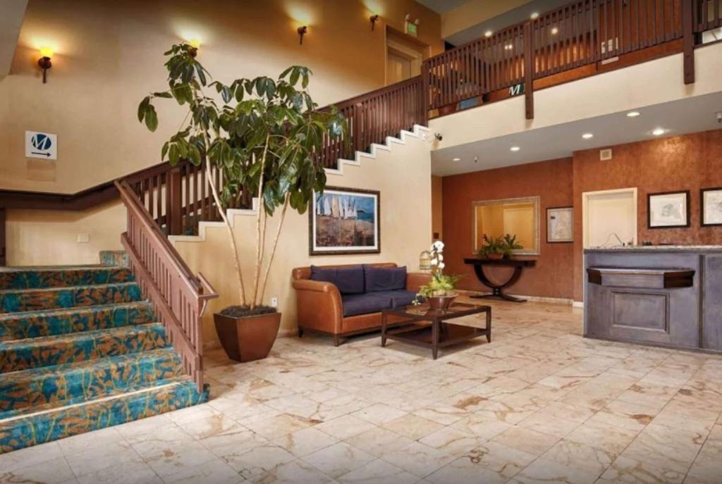 a lobby with a staircase and a living room at Pacifica Lighthouse Hotel Trademark Collection by Wyndham in Pacifica
