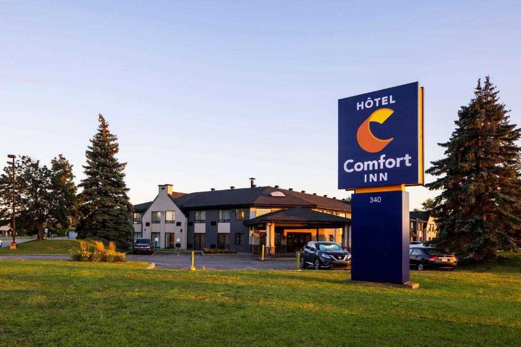 una señal de hotel frente a una posada con garaje en Comfort Inn Aeroport, en Dorval