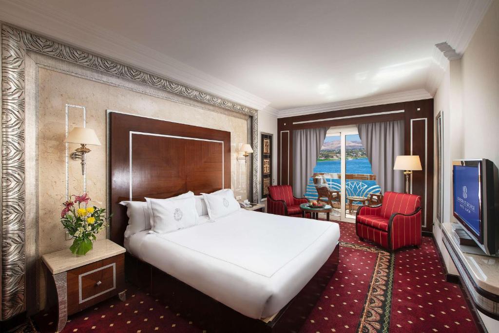 a hotel room with a bed and a television at Sonesta St. George Hotel - Convention Center in Luxor