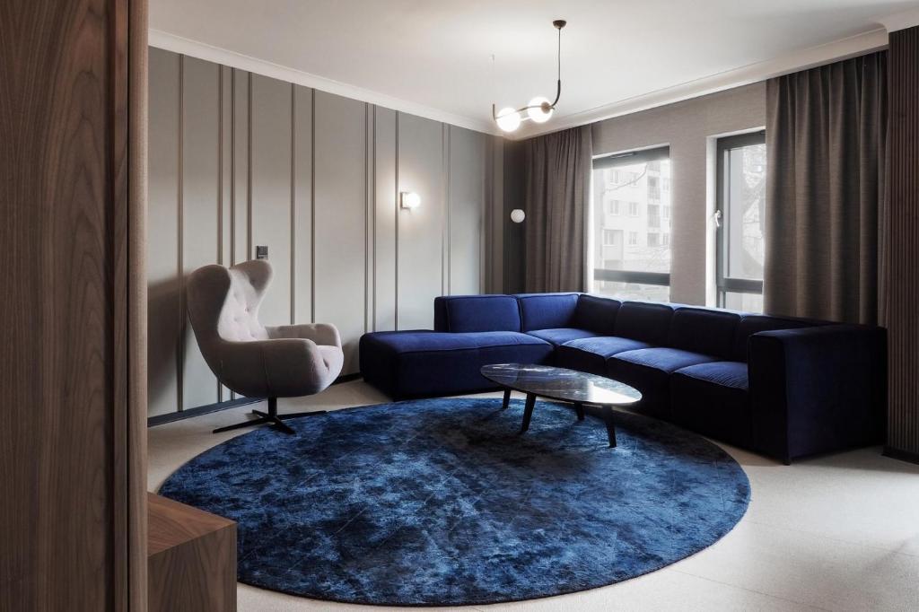 格地尼亞的住宿－Awanport Gdynia M apartments，客厅配有蓝色的沙发和蓝色的地毯。