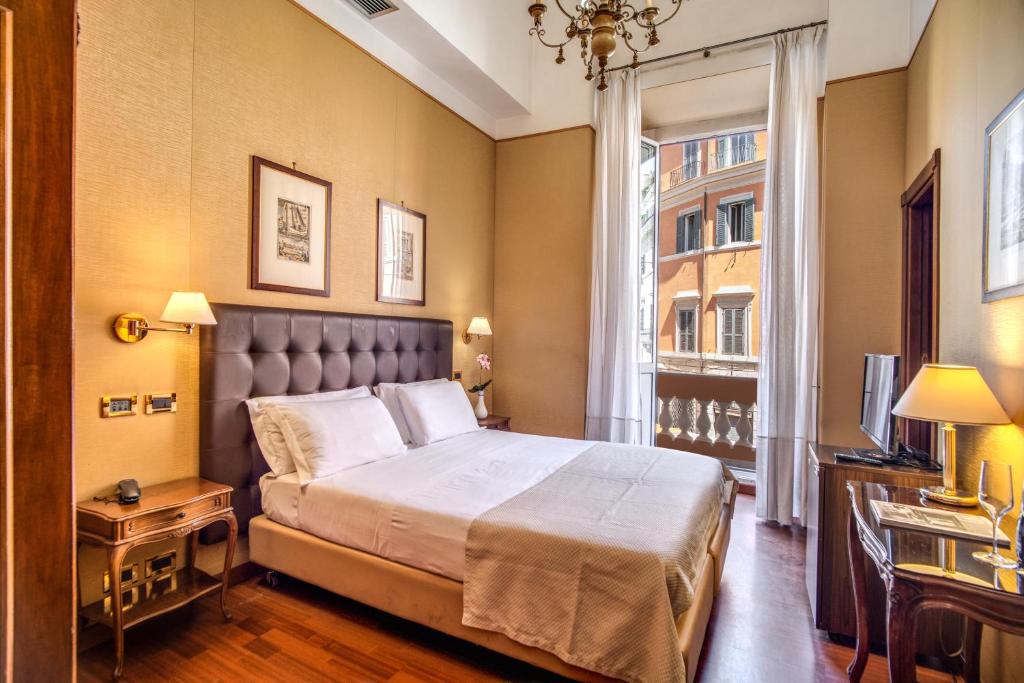 una camera con un grande letto e una finestra di Hotel Della Torre Argentina a Roma
