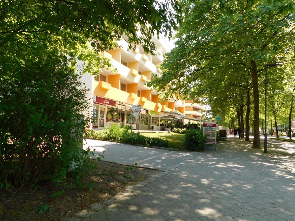 un bâtiment dans une rue bordée d'arbres et d'un trottoir dans l'établissement Zentral Hotel, à Bad Füssing