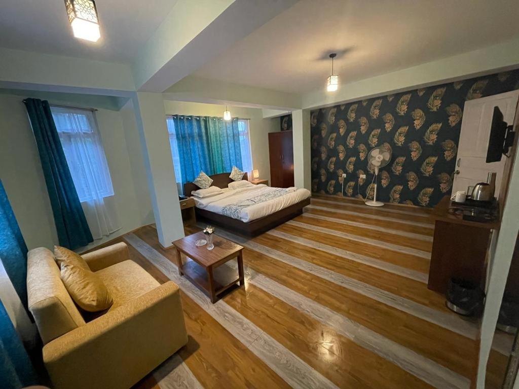 een woonkamer met een bed en een bank bij The Better Inn in Gangtok