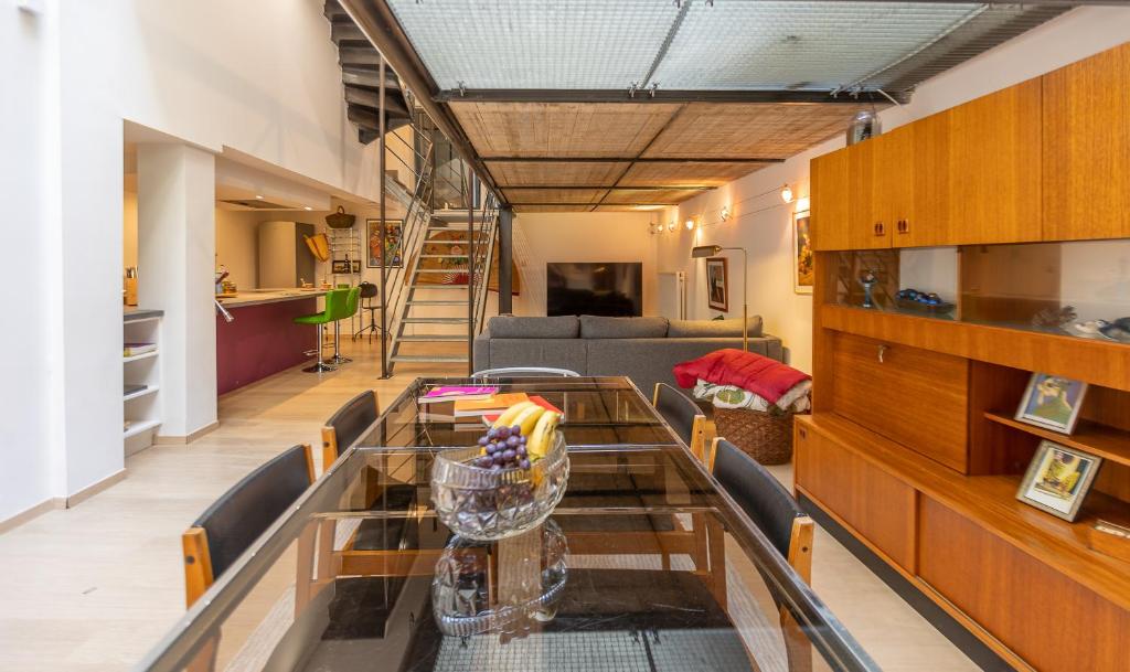 a dining room and living room with a glass table at Le Loft Nautilus - Maison Brasseurs d'Etoiles in Liège