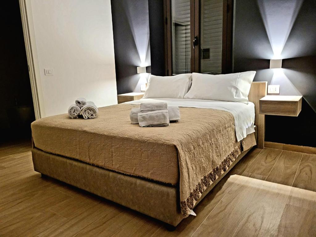 een slaapkamer met een groot bed en handdoeken bij B&B La Cité Luxury Rooms in Reggio di Calabria