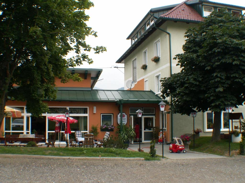 un pequeño coche rojo estacionado frente a un edificio en Gasthof-Pension Hochsteiner, en Glödnitz