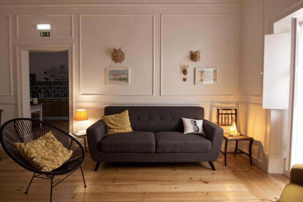 uma sala de estar com um sofá e uma cadeira em Patinha Inn em Évora