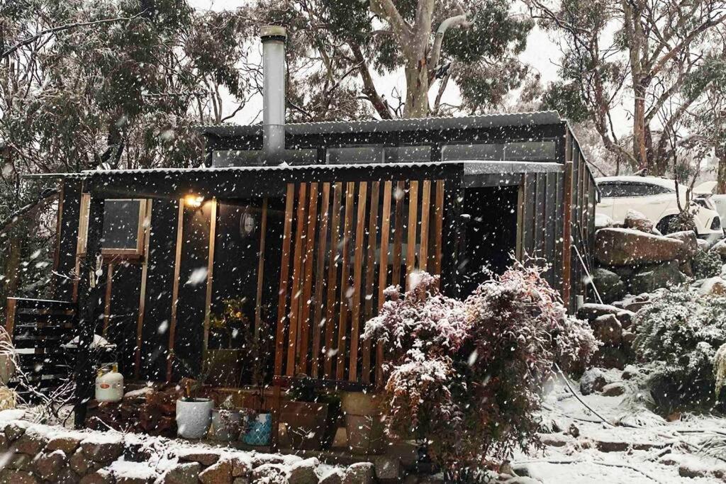 a small shed covered in snow in a yard at ReThynk Unique Tiny home East Jindabyne in Jindabyne
