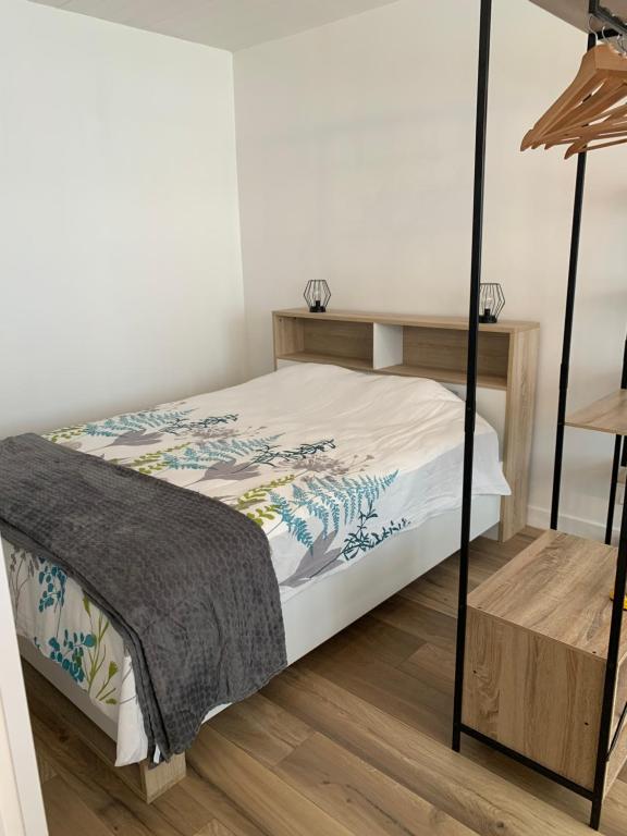 a bedroom with a bed and a wooden floor at Studio des thoniers in Concarneau