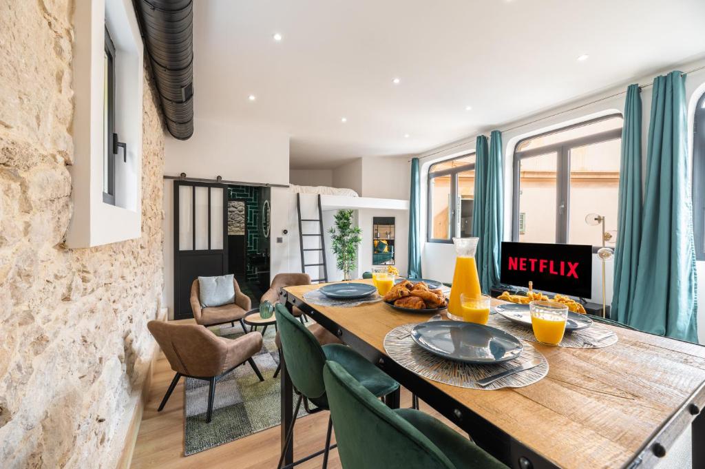 una sala da pranzo con tavolo in legno e sedie verdi di LOFT DESIGN AUX PORTES DE MONACO a Beausoleil