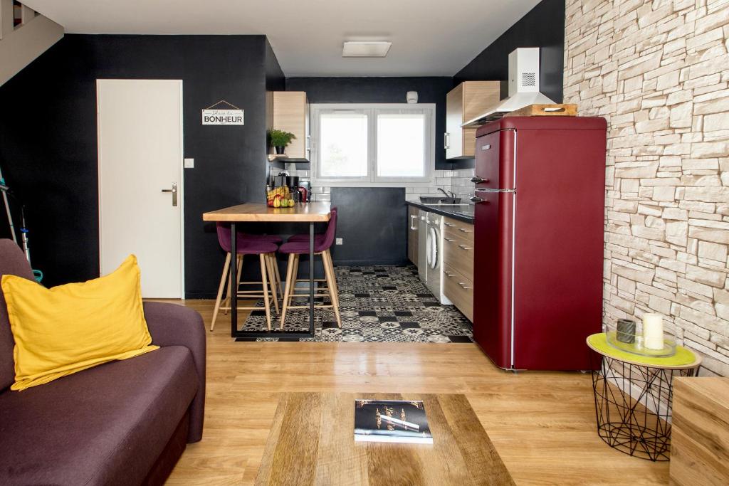 a kitchen with a red refrigerator and a table at Appartement neuf style industriel *** proche de la mer in Roscoff