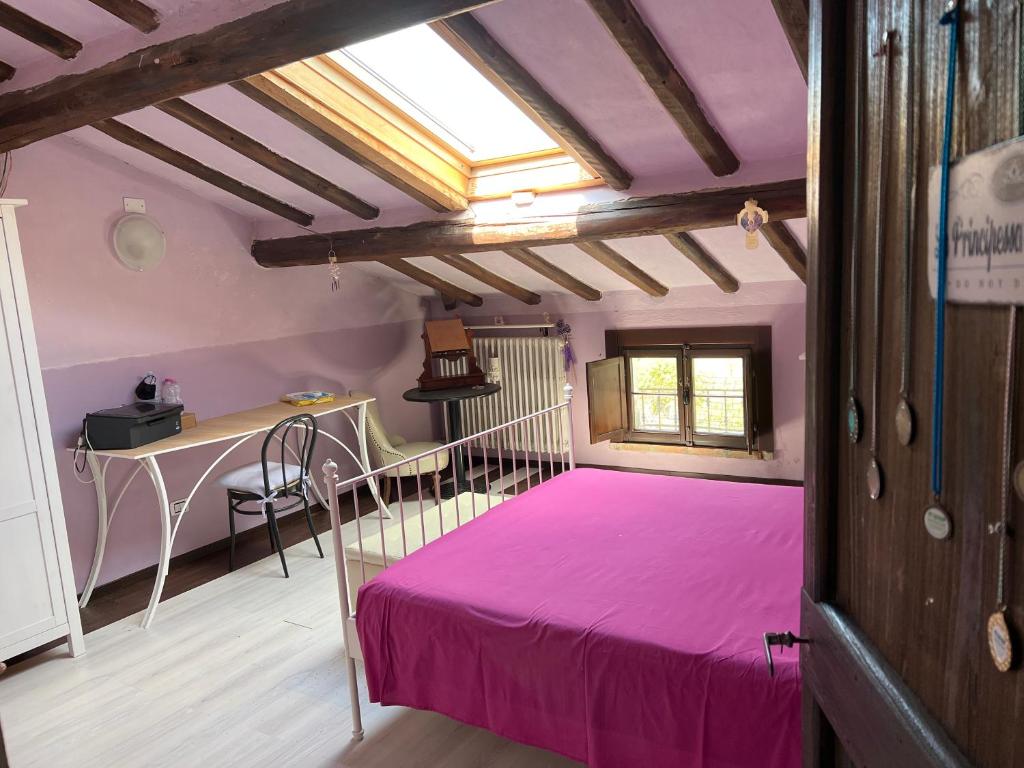 sypialnia z różowym łóżkiem i biurkiem w obiekcie La Frasca w mieście Coltaro