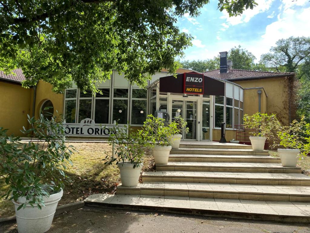 a building with stairs in front of a building at Enzo Hôtels Premier Prix - Logis Amnéville in Amnéville