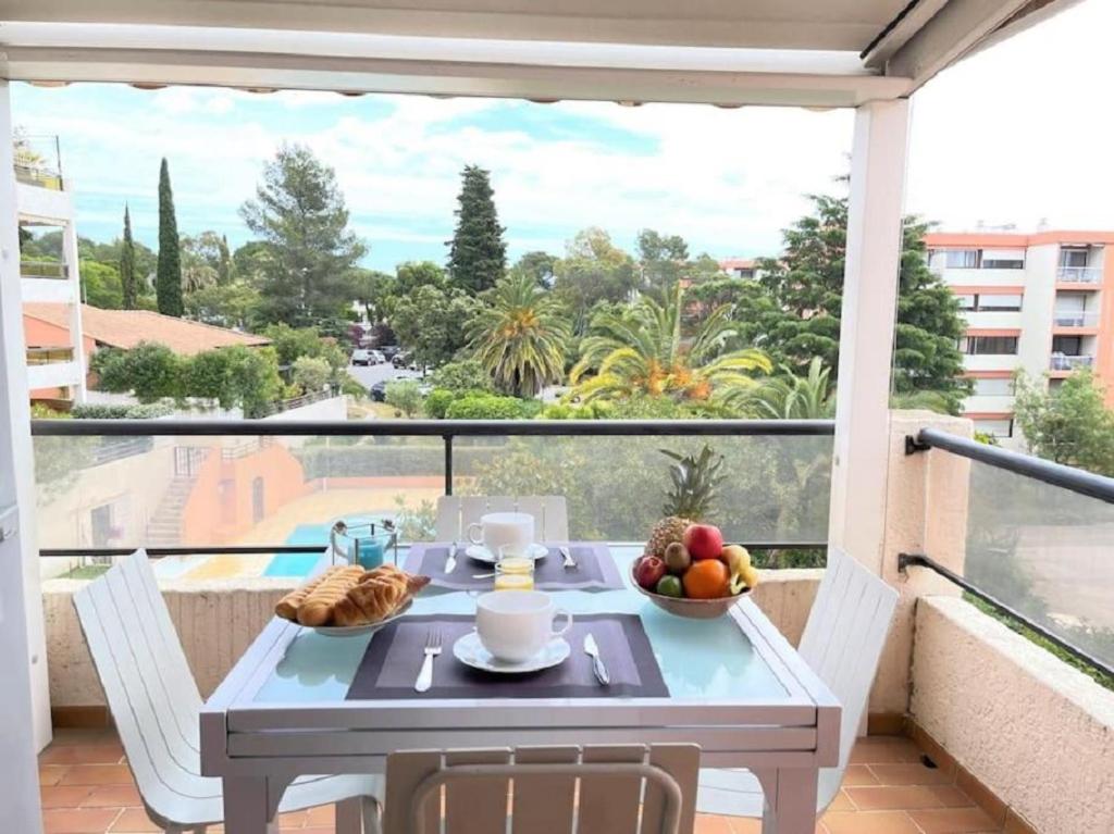 une table avec un bol de fruits sur un balcon dans l'établissement Appartement Imperia St Raphaël, au calme, vue piscine, climatisé, à Saint-Raphaël