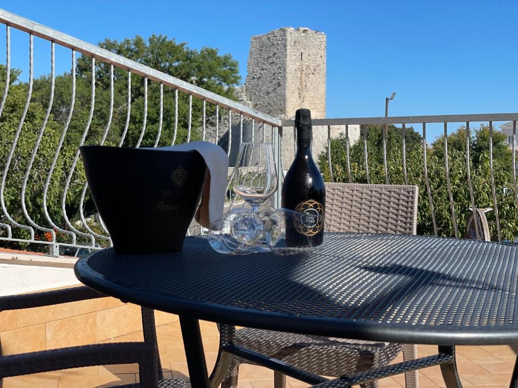 uma garrafa de vinho e dois copos numa mesa em Gli Angeli - Affittacamere em Monte SantʼAngelo