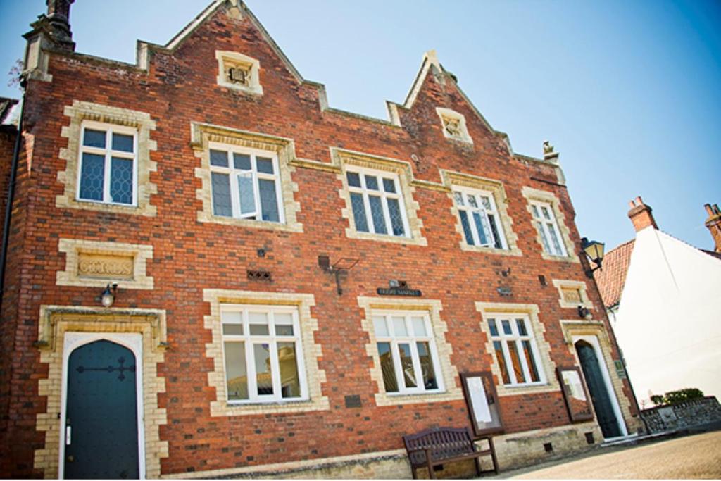 a large brick building with a door in front of it at Elmham House - Pilgrim Hotel in Little Walsingham