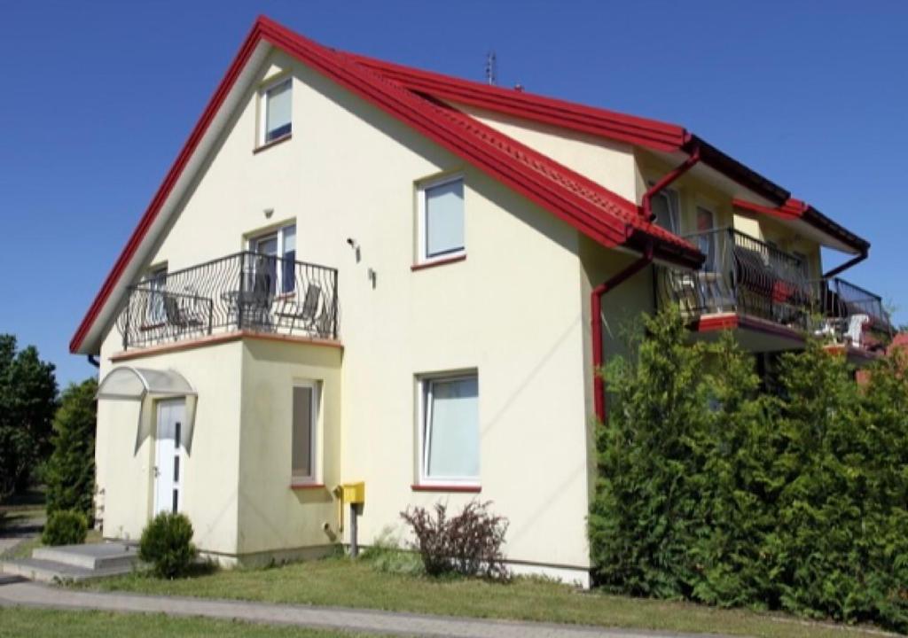 uma casa branca com um telhado vermelho em Lorens Family em Mikolajki