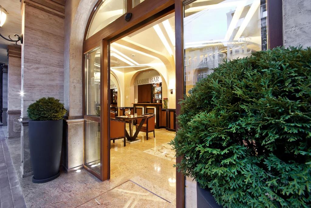 ソフィアにあるベストウエスタン プラス ブリストル ホテルの大きなガラスドアと鉢植えの植物があるロビー
