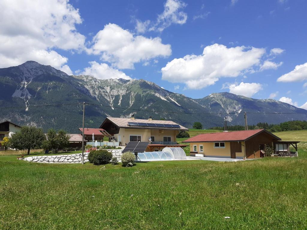 ein Haus auf einem Feld mit Bergen im Hintergrund in der Unterkunft Ferienwohnung Alpenblick in Hermagor