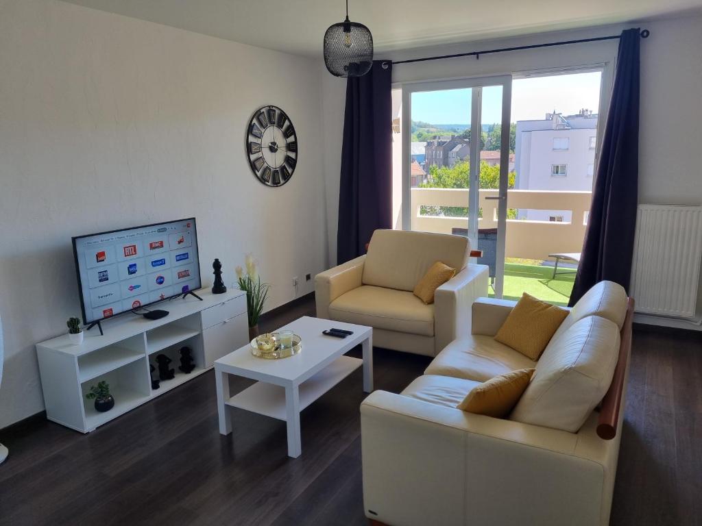 sala de estar con sofá y TV en Bel appartement 2 chambres ,résidence privée, en Givet