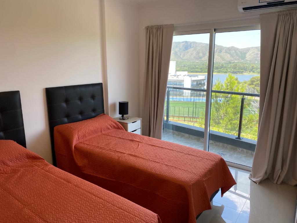 ein Schlafzimmer mit zwei Betten und einem großen Fenster in der Unterkunft Departamento con vistas al lago en Veneto Village in Villa Parque Siquiman