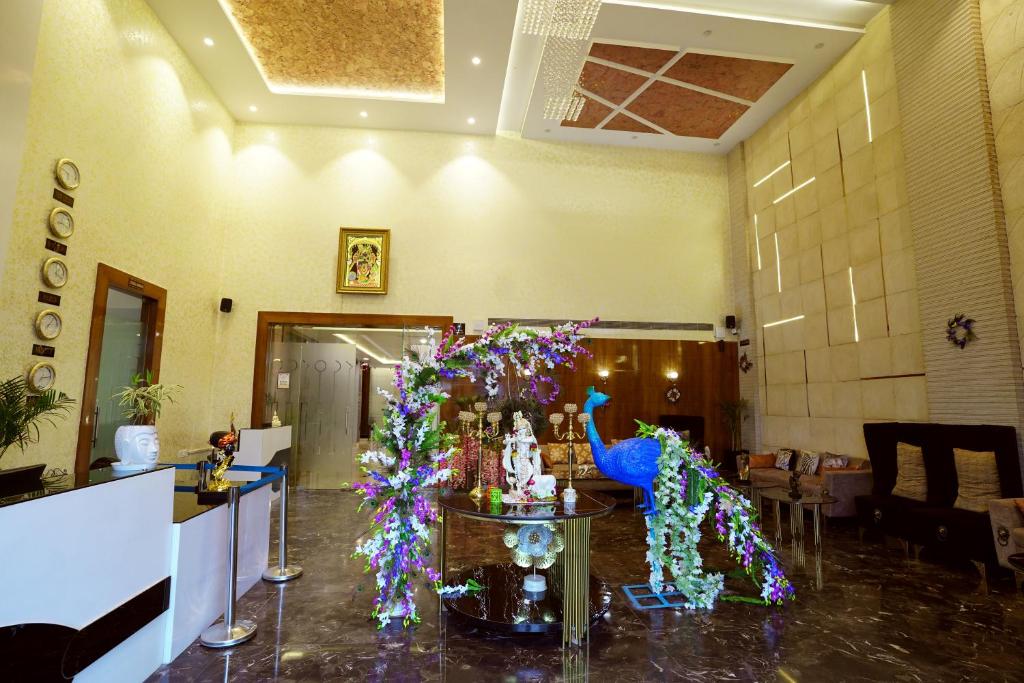 una sala de estar con una mesa con flores y un centro de mesa en Hotel Idhayan Palace, en Vrindāvan