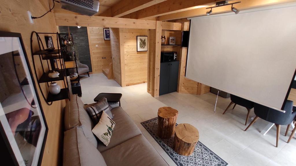 a living room with a couch and a projection screen at Valley Lodge in La Bresse