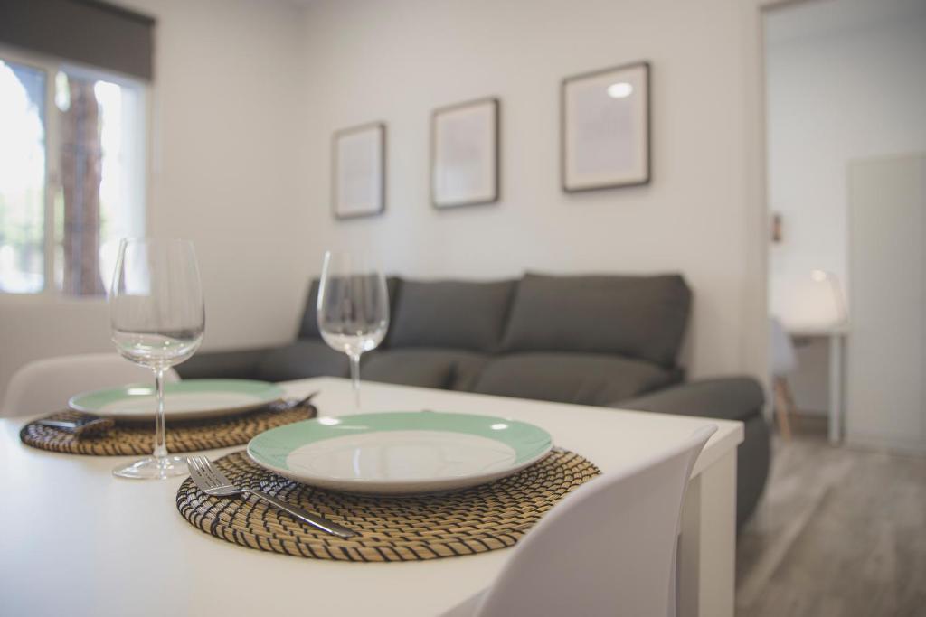 uma mesa com dois pratos e taças de vinho em Acogedor apartamento en Triana em Sevilha