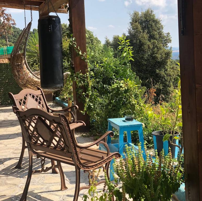 a patio with two chairs and a blue table at Yogaville Sardegna in Luras