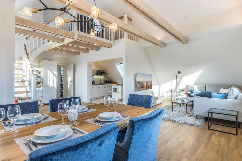 a dining room and living room with a table and chairs at Appartement Friesenloft in Tinnum
