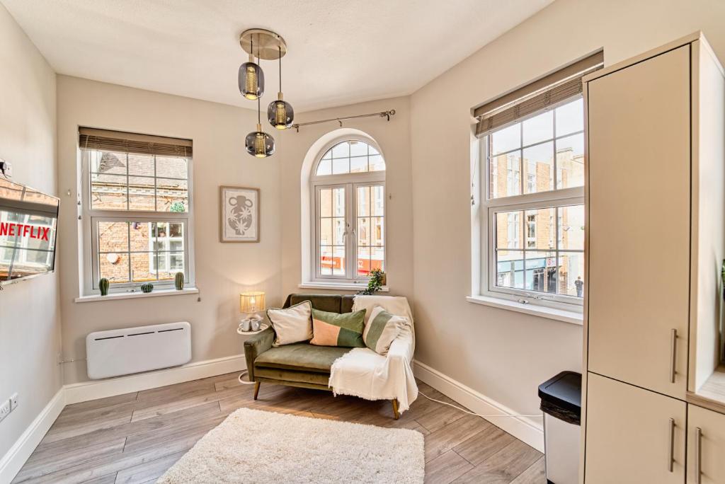 a living room with a chair and windows at Guest Homes - Bennett Apartment in Worcester