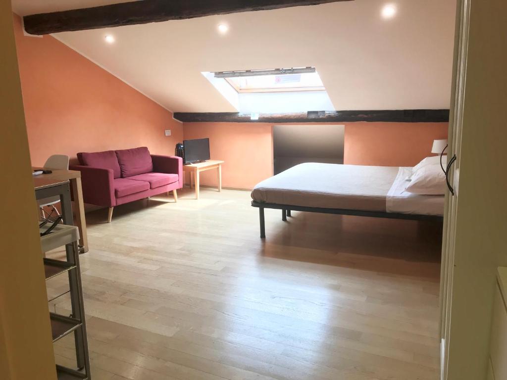 een slaapkamer met een bed en een roze bank bij Casa Cairoli in Milaan