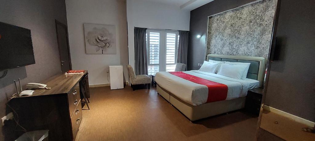 um quarto de hotel com uma cama e uma televisão em EMAN HOUSE em Salalah