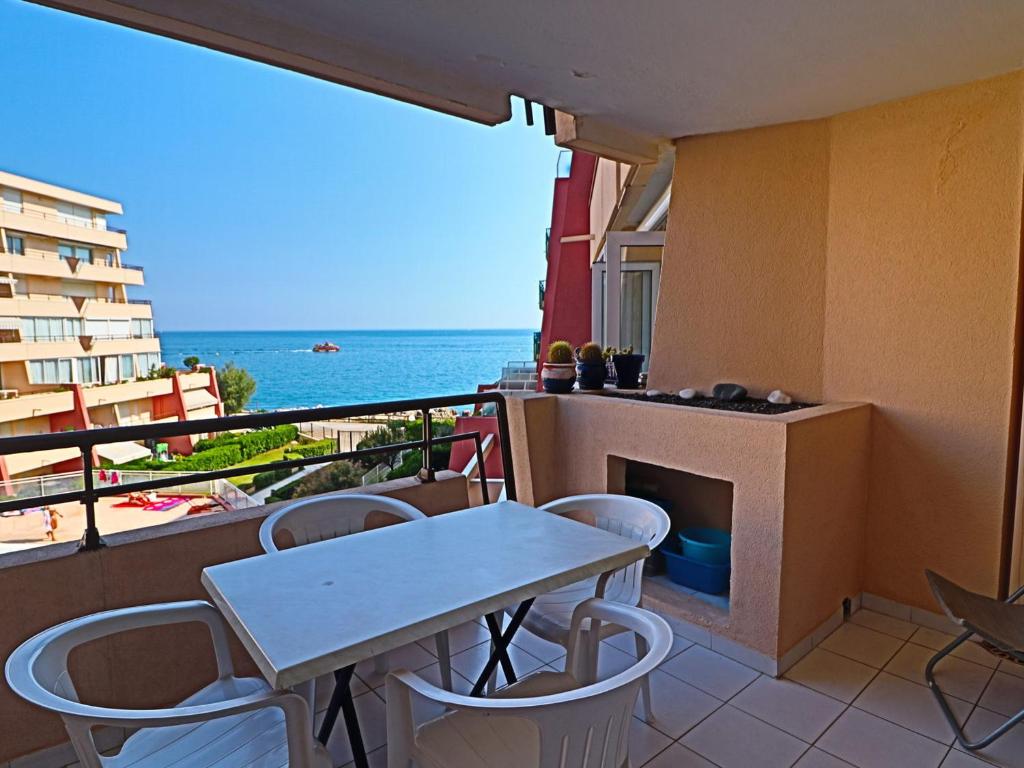 une table et des chaises sur un balcon avec vue sur l'océan dans l'établissement Appartement 2 pièces cabine pour 6 pers avec terrasse et parking - FR-1-472A-174, à Sète