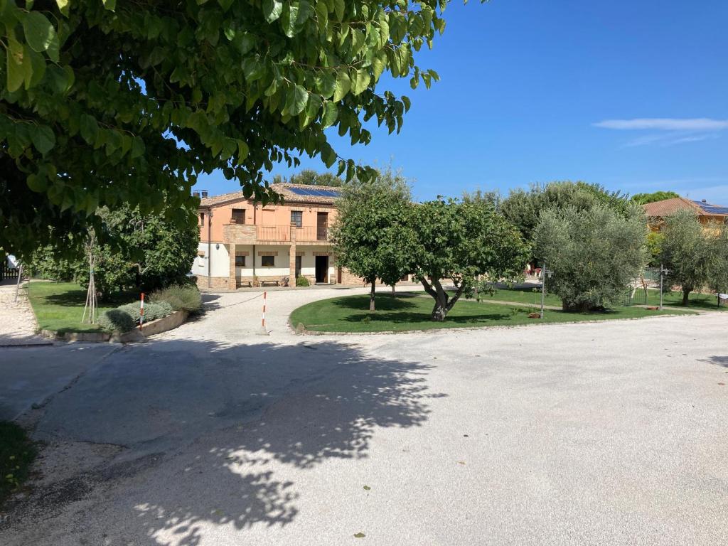 eine leere Straße vor einem Gebäude mit Bäumen in der Unterkunft Azienda Agrituristica Le Bucoliche in Osimo