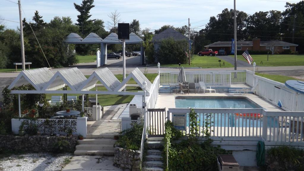 a house with a swimming pool and a white fence at Twin Lakes Inn in Bull Shoals