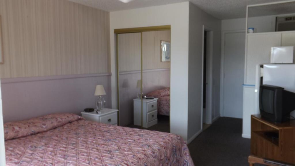 a hotel room with a bed and a tv at Twin Lakes Inn in Bull Shoals