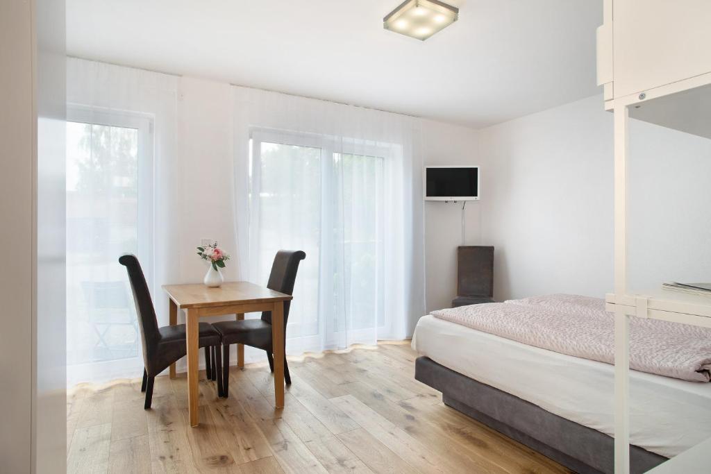 Schlafzimmer mit einem Bett und einem Tisch mit Stühlen in der Unterkunft Apartment Landzeit in Neukirch