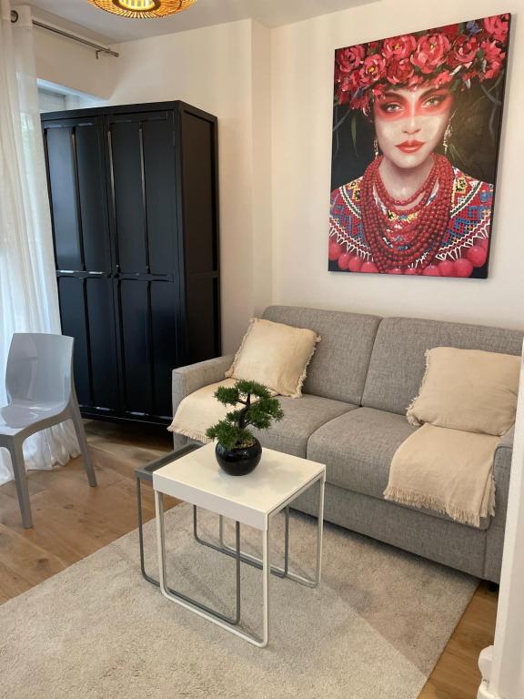 una sala de estar con sofá y una pintura de una mujer en Paris 16 Victor Hugo superbe studio, en París