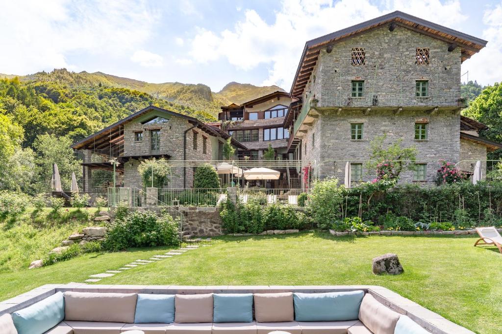 a large stone house with a couch in the yard at Country House La Bursch in Campiglia Cervo