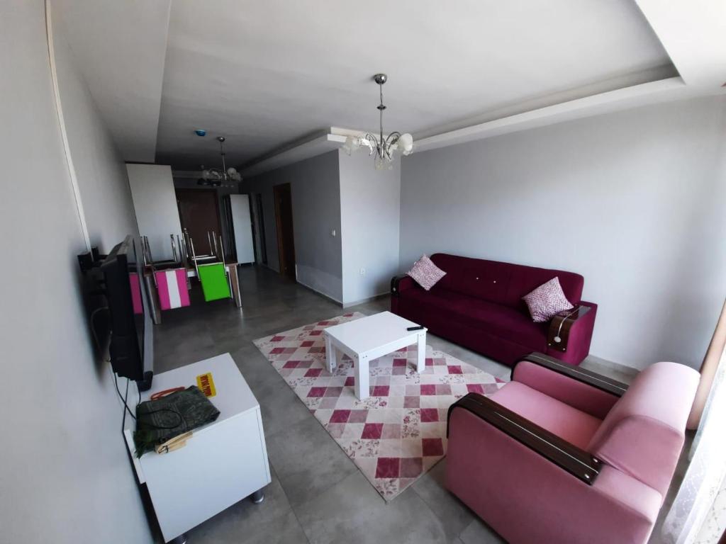 a living room with a red couch and a table at gazlıgöl elit termal otel in Gazligol