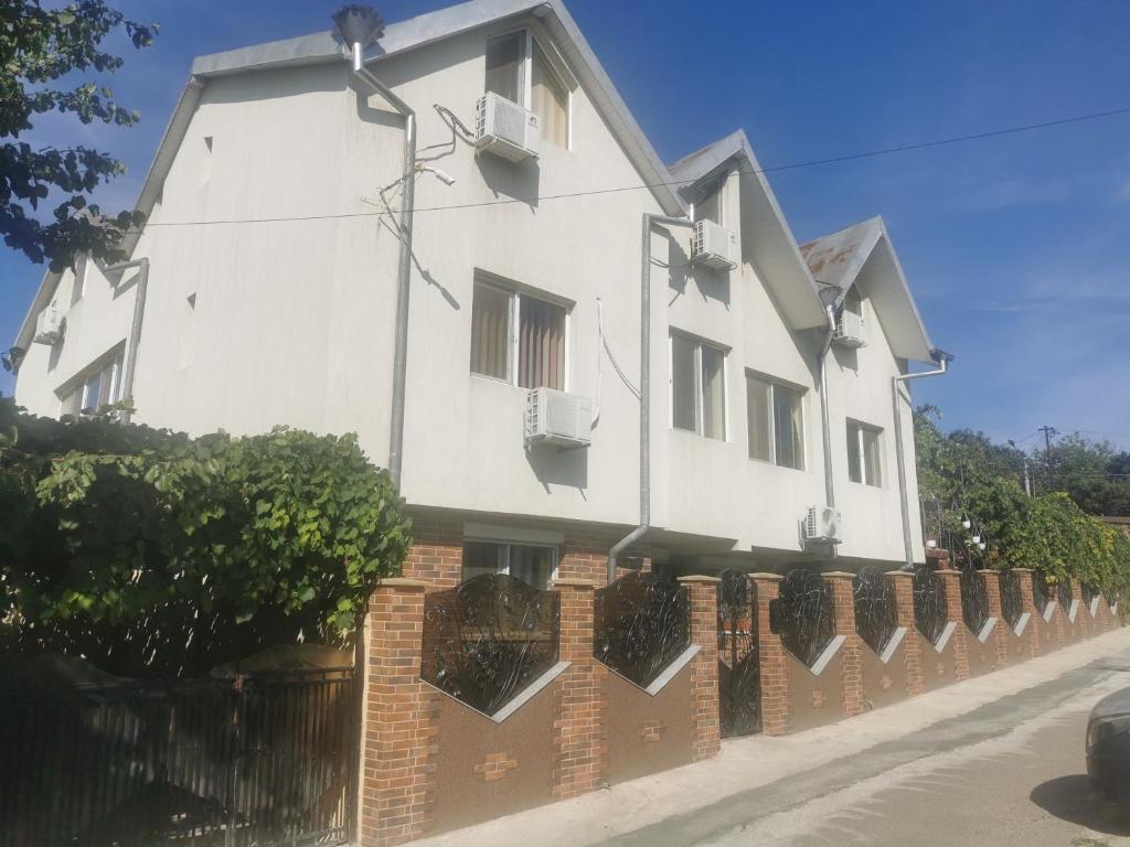 a white house with a brick fence at PENSIUNEA EDWARD in Eforie Sud