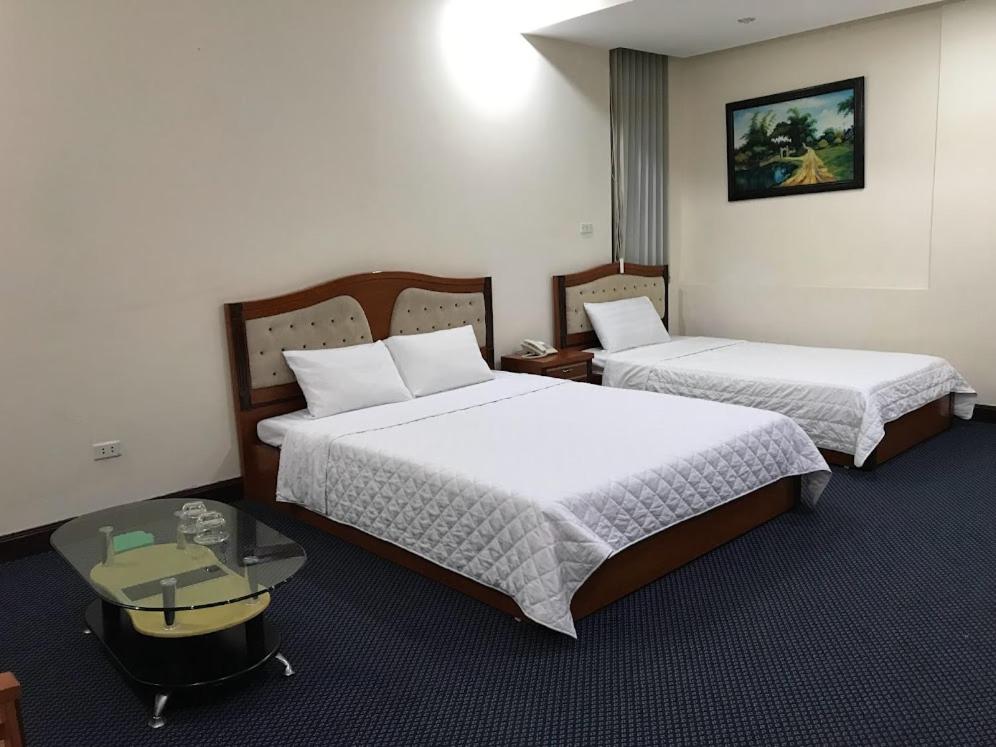 a hotel room with two beds and a table at Thien Anh Hotel in Hai Phong