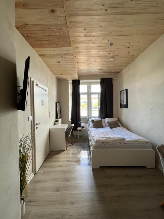 a bedroom with two beds and a wooden ceiling at Öko Lehmbau direkt am Main in Marktbreit